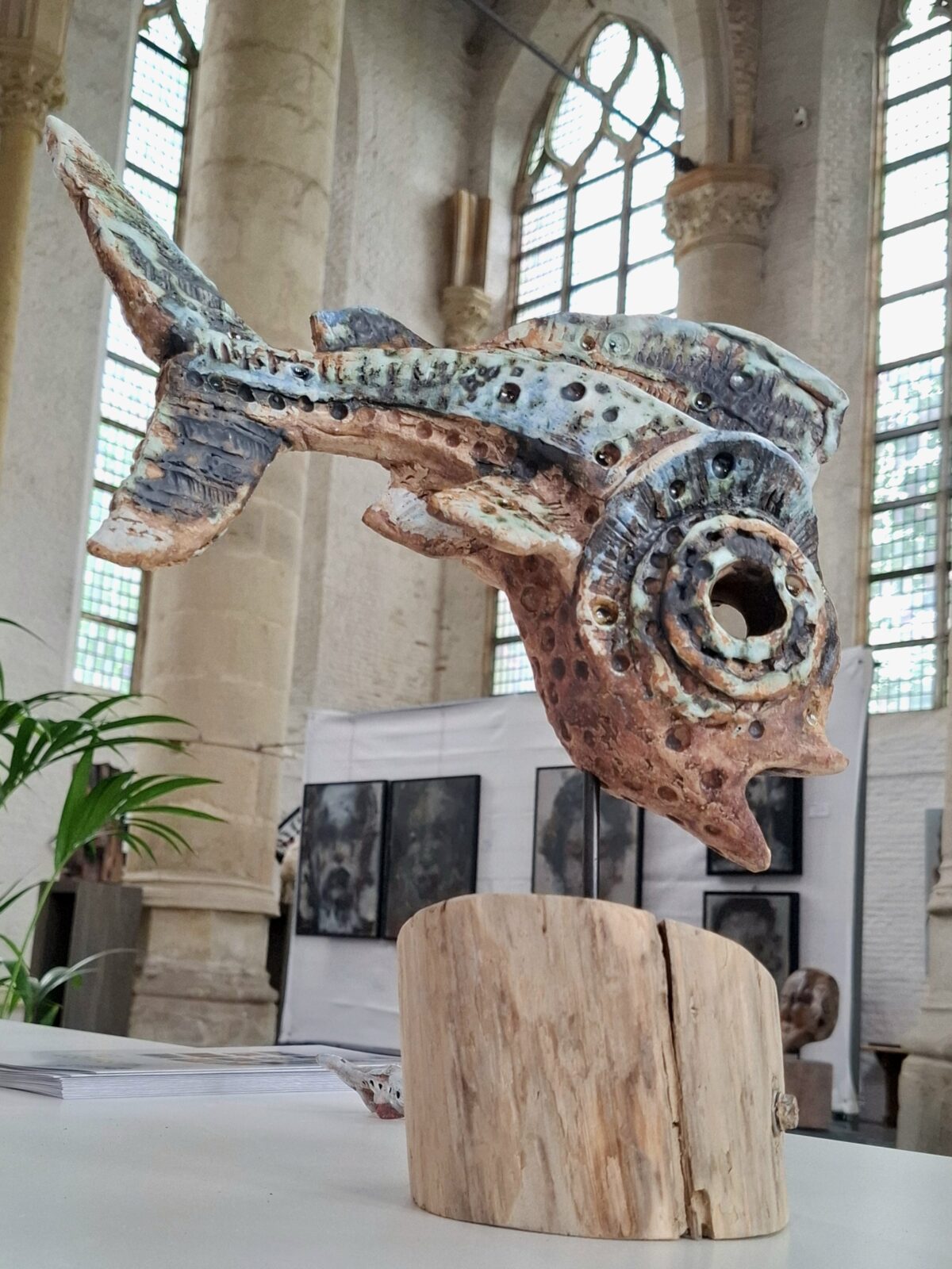 Handgemaakte keramieken vis op sokkel van drijfhout tijdens de expositie Goes En Passant in de Grote Kerk van Goes, juni 2026